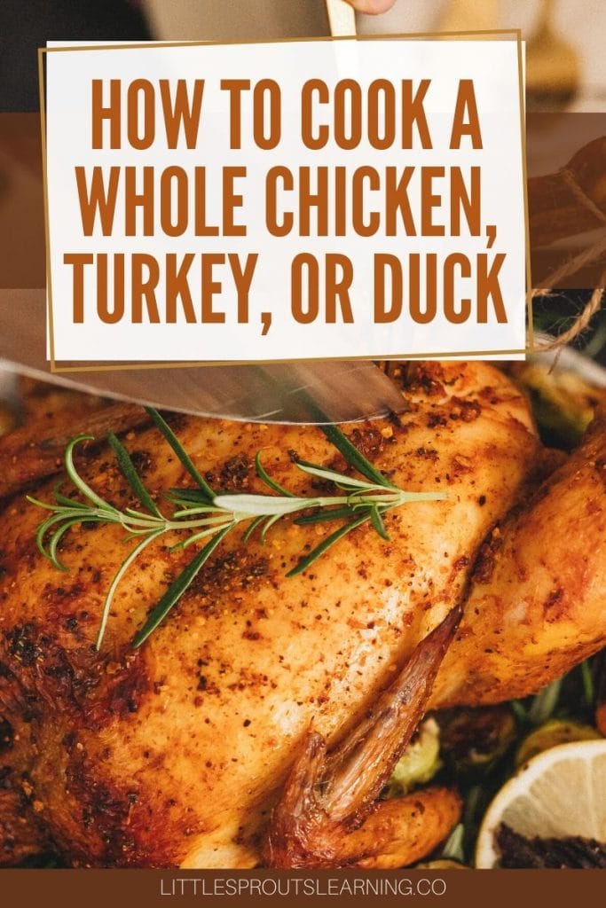 roasted whole chicken on a plat with a sprig of rosemary and a knife and a fork about to cut into it.