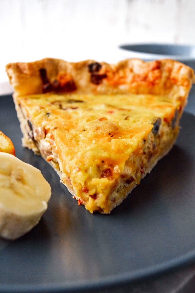 slice of quiche on a plate with slices of banana
