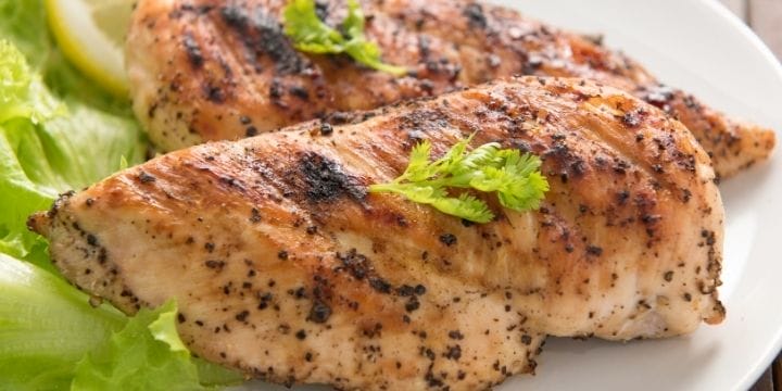 air fryer chicken breasts on a plate garnished with herbs