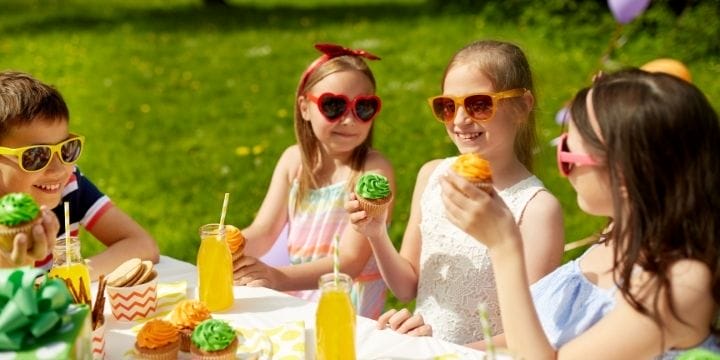 Kids wearing sunglasses with party food and party drinks at a table