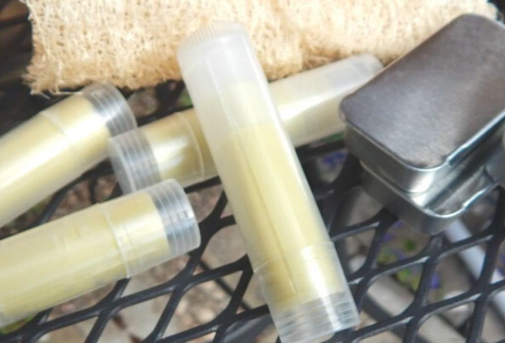 Bug bites sticks and salve tins laying on a table with some luffa