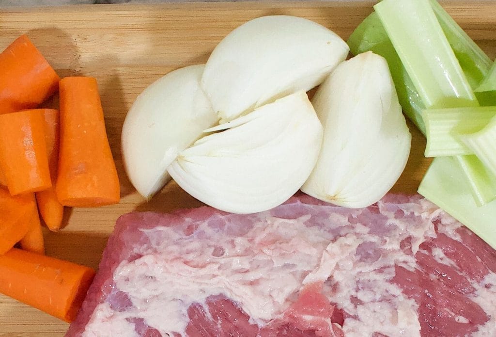 corned beef ingredients including brisket, onions, celery, and carrots.
