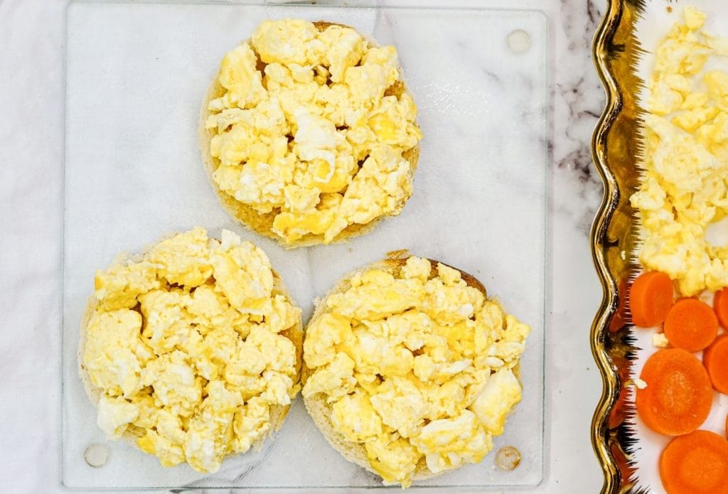 toast rounds topped with scrambled eggs on a board