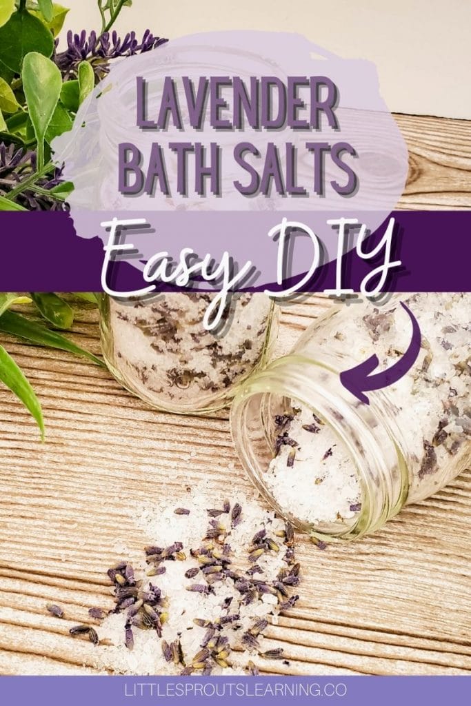 lavender bath salts on a table, one jar upright and one spilling out with plants next to them