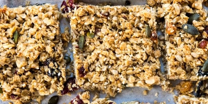 nut free granola bars with oats and seeds cut into squares on a board
