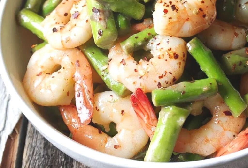 shrimp and asparagus stir fry in a bowl