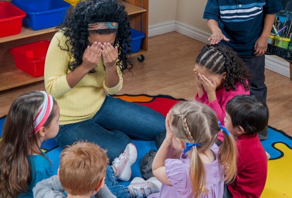 daycare kids and teacher playing duck duck goose