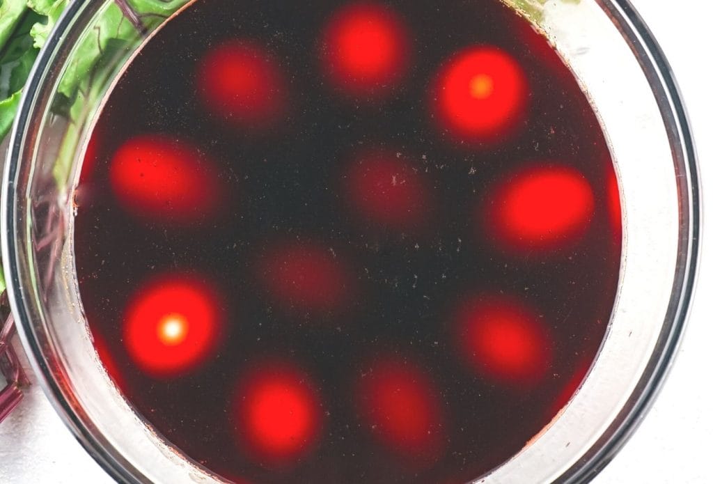 boiled eggs in a bowl of red water (from beets)