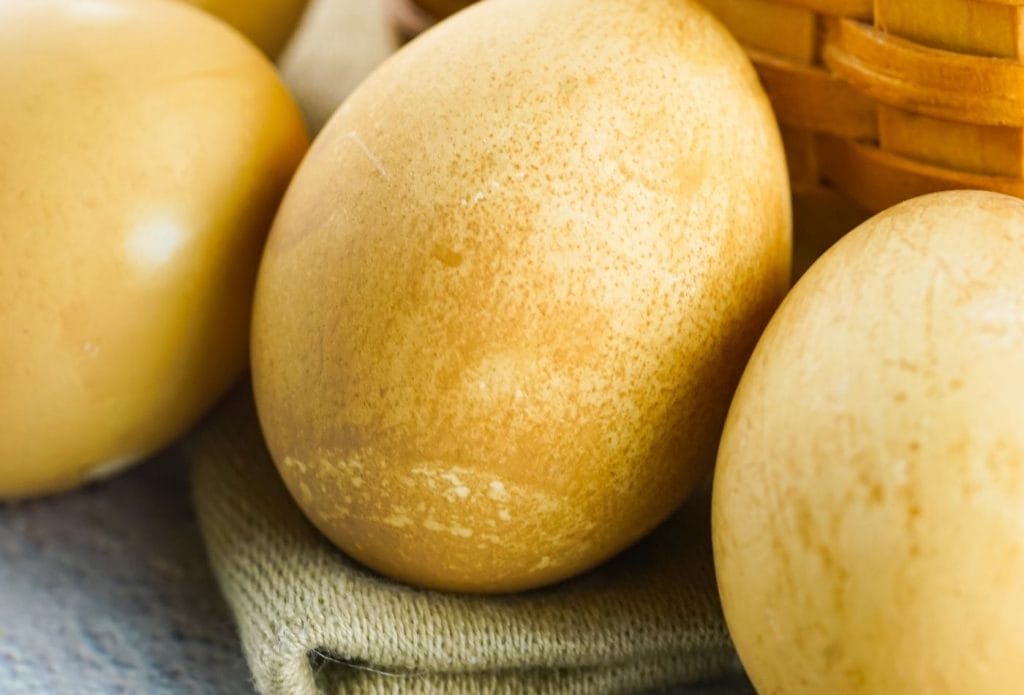 brown dyed easter eggs on a towel by a basket