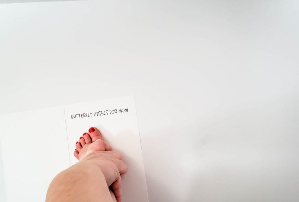 hand pressing baby's foot onto mother's day card