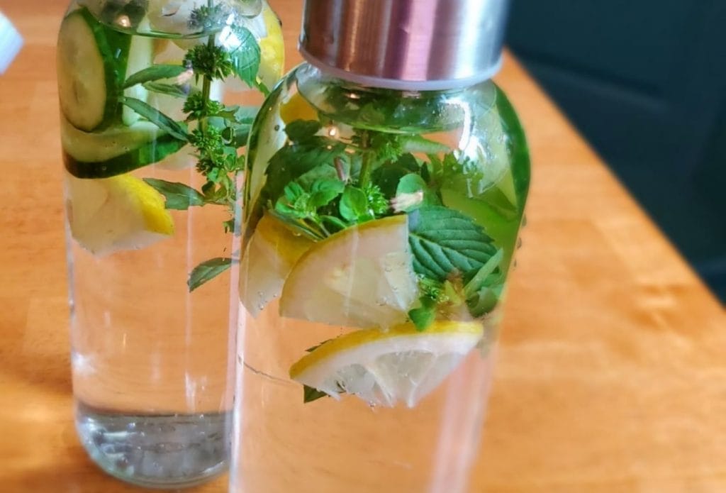 lemon infused water with blue spice basil in a bottle on the table