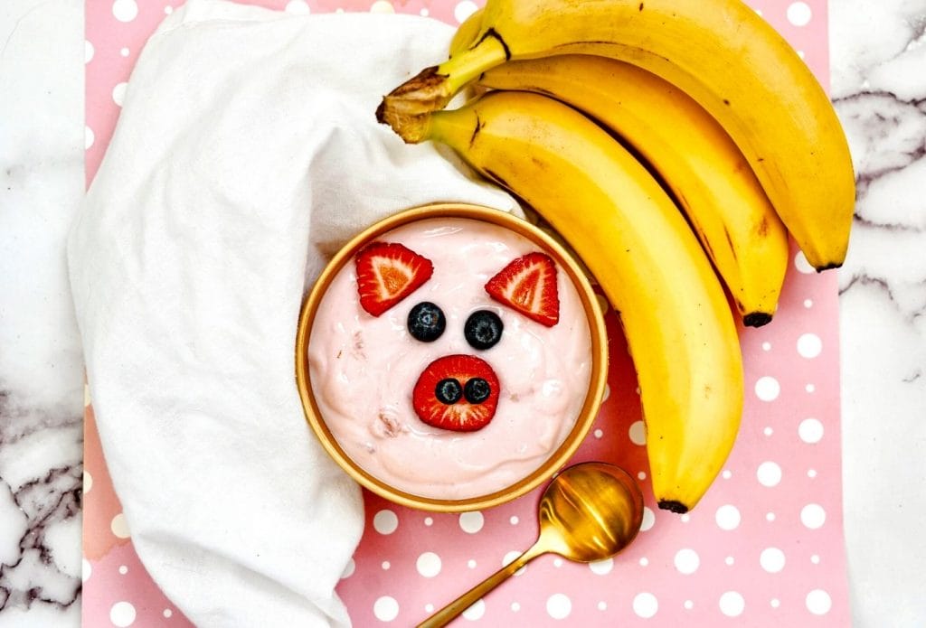 Pig yogurt bowl with bananas and a dish towel