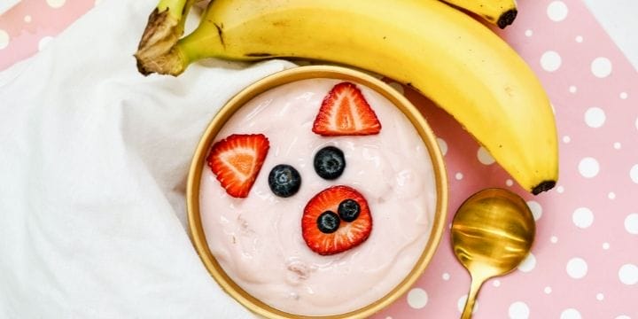 close up of pink yogurt pig face bowl and a banand