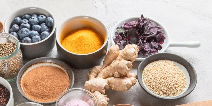 superfoods on a counter such as ginger, turmeric, and more