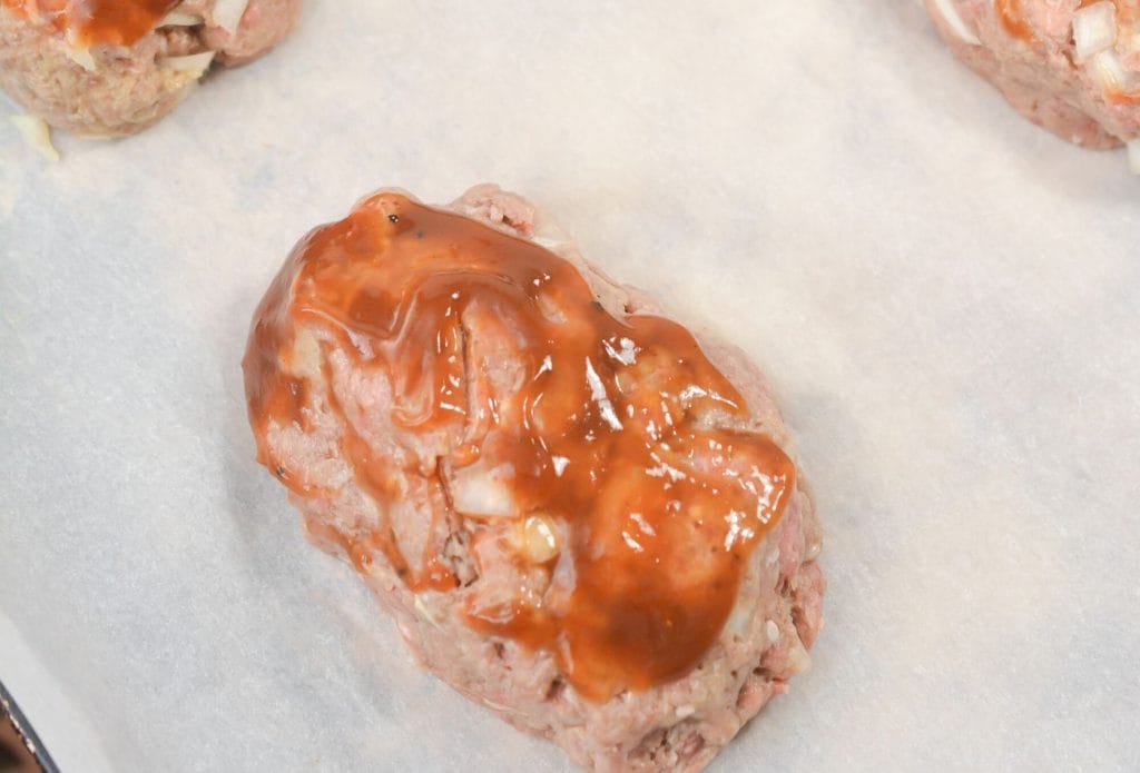 small raw meatloaf with bbq sauce on a plate