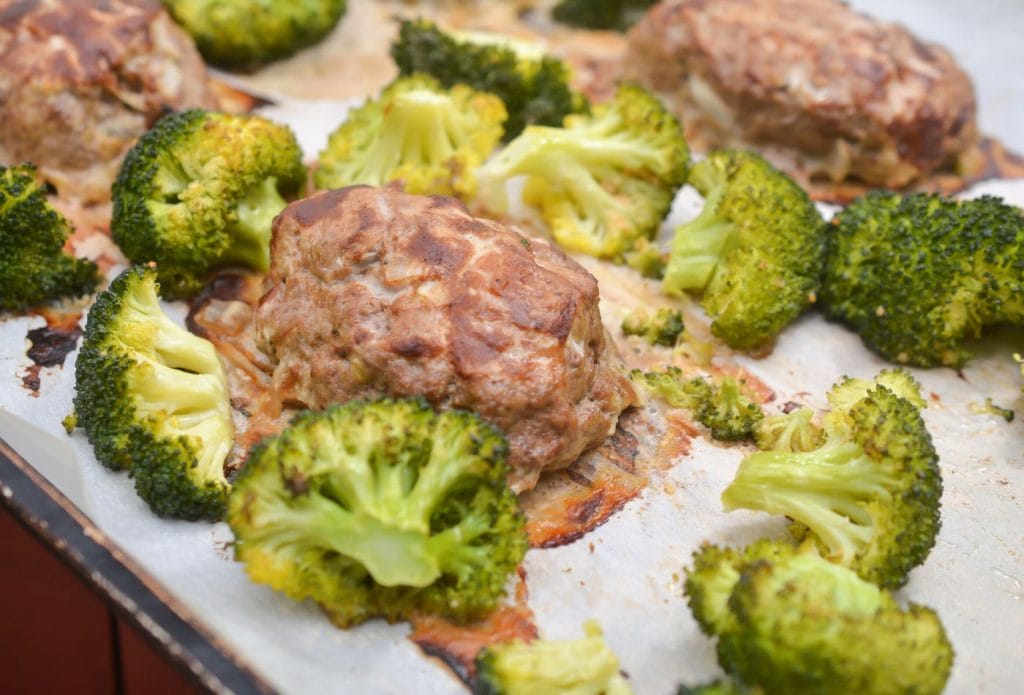 mini meatloaves and broccoli cooked on a sheet pan