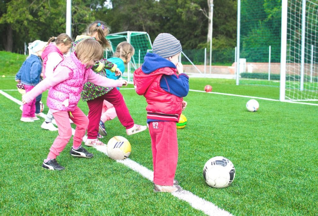 children kicking a ball outside