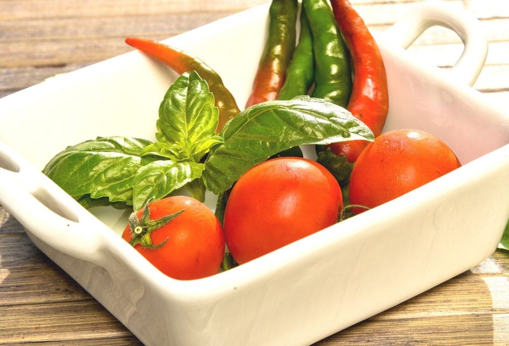 tomatoes, basil, and hot peppers in a bowl