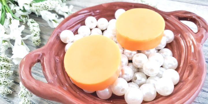 orange lotion bars on a plate of pearls