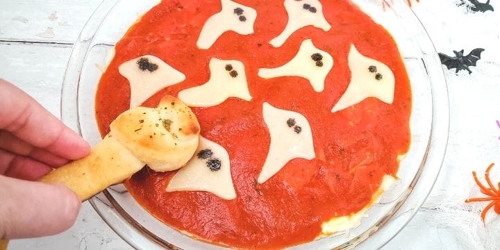 ghost pepperoni dip in a bowl with a twisted bread bone