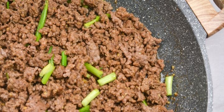 mongolian ground beef in a skillet with green onions