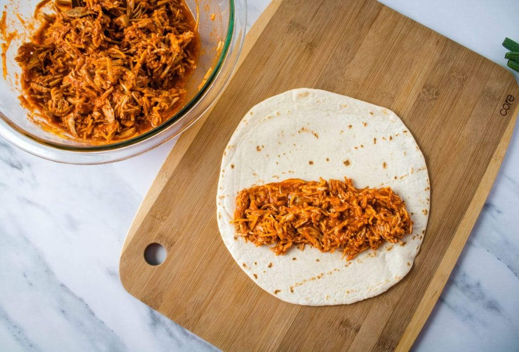 tortilla with pulled pork covered in enchilada sauce