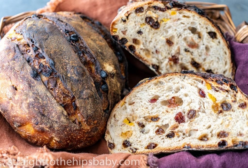 beautiful sourdough raisin bread loaf cut in half in a basket