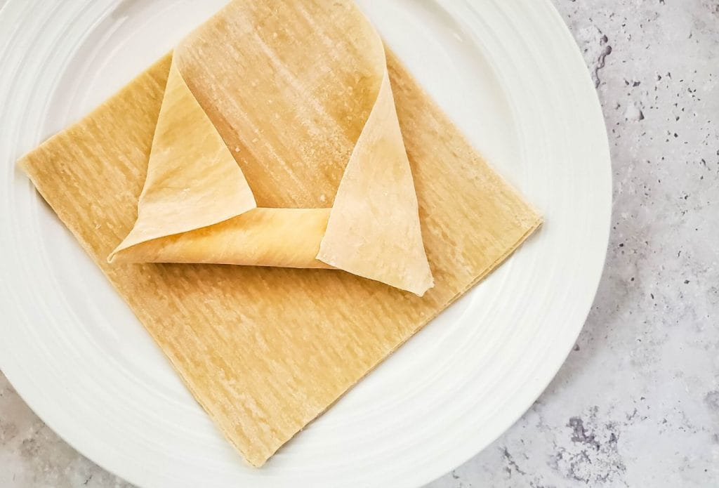 string cheese on a wonton wrapper being rolled up