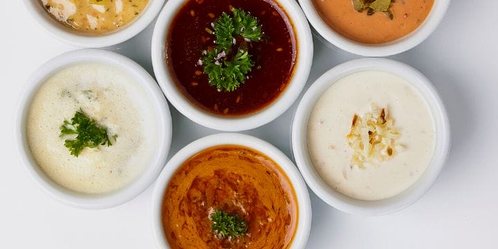 sauces and dressings in bowls arranged on a board