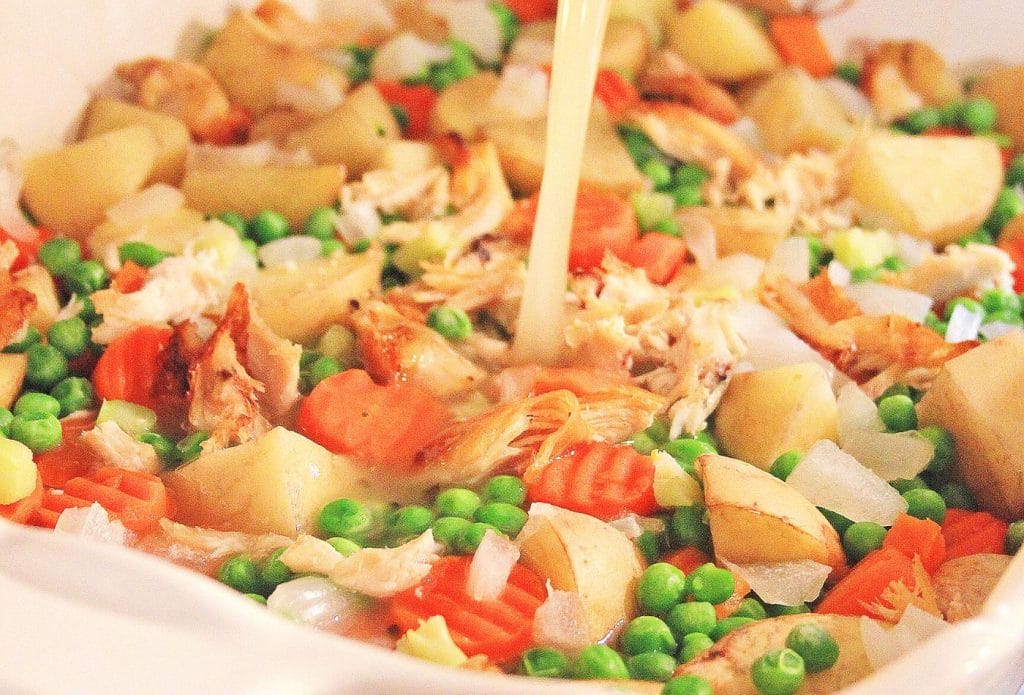 chicken stock pouring into chicken casserole