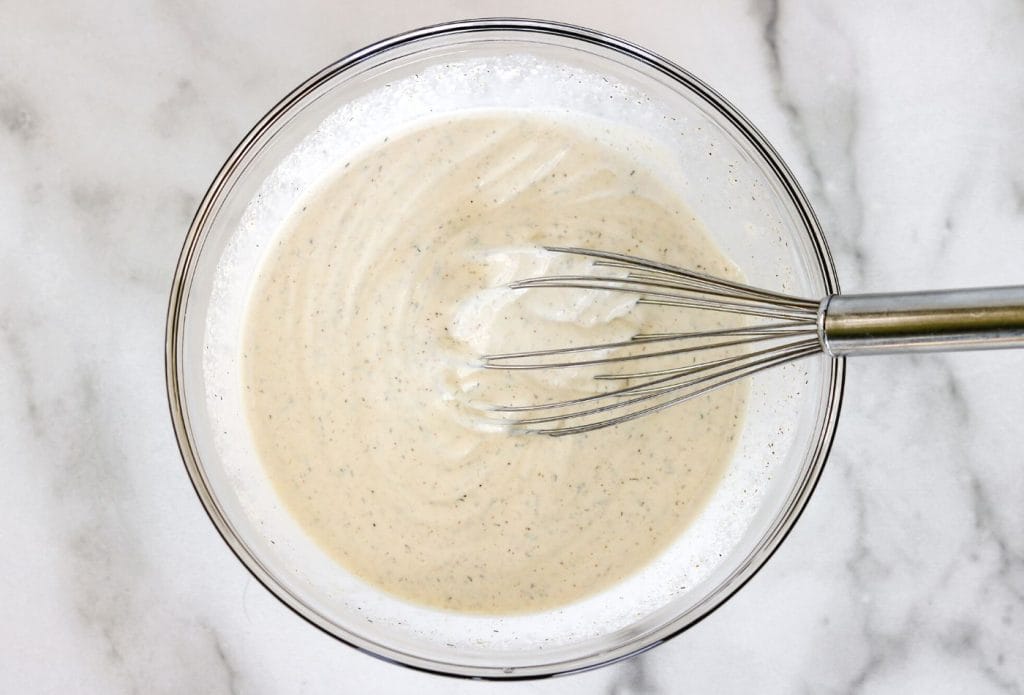 bowl of dressing being mixed up with a whisk