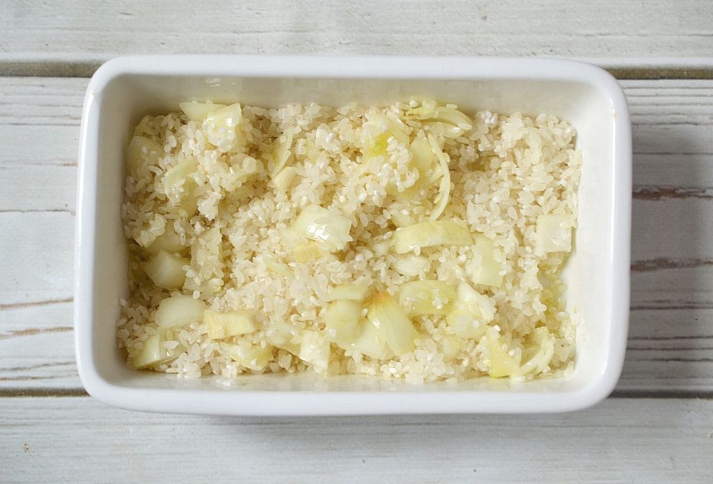 rice and onions mixed together in a dish