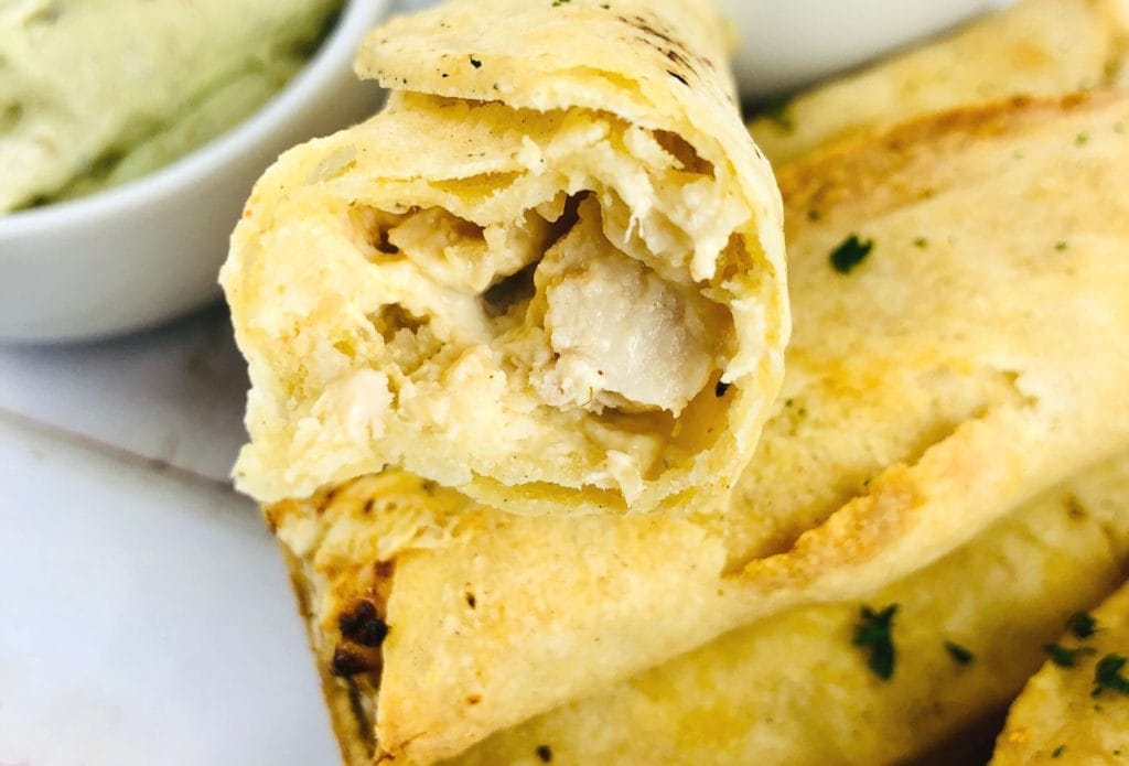 chicken taquito with a bite out balanced on another