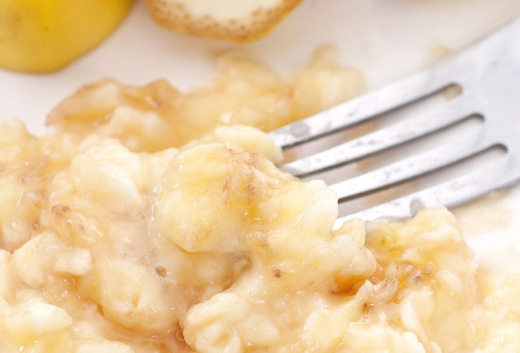a fork mashing banana into puree