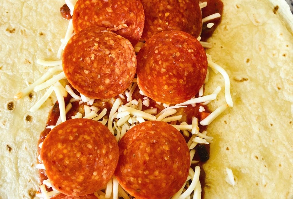 Pepperoni pizza quesadilla being filled
