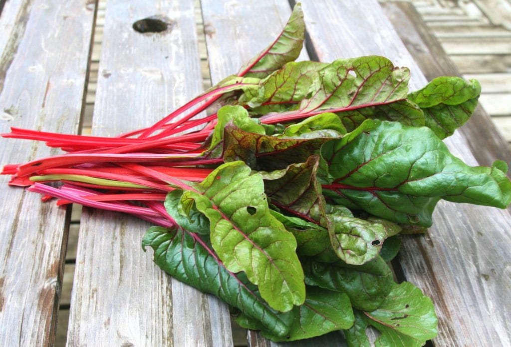 bundle of swiss chard on a board