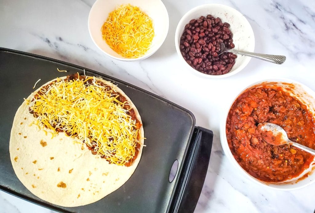 Making quesadillas on a board with toppings around