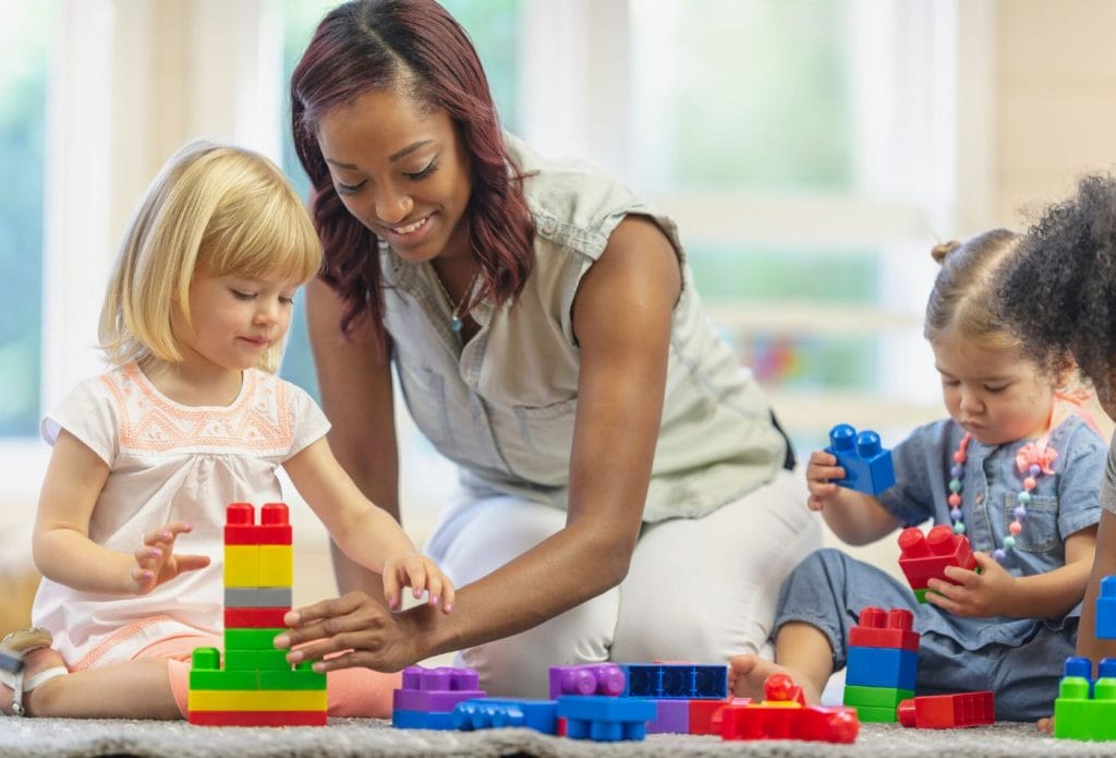 grown up playing blocks with preschool kids