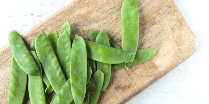snow peas fresh on a board