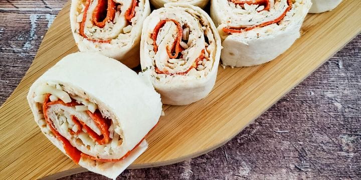 pepperoni cream cheese roll ups sliced up on a board