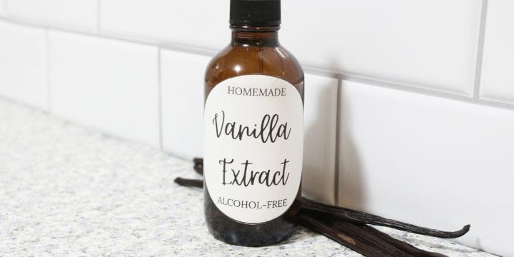 small bottle of alcohol free vanilla extract on the counter with vanilla beans