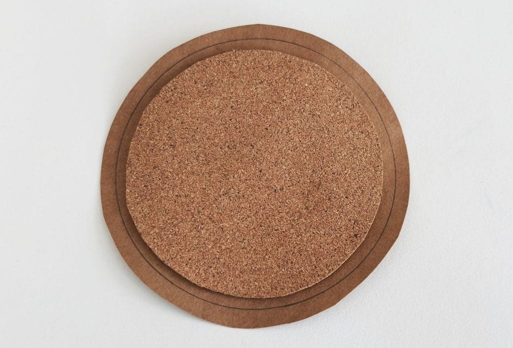 a circle being cut out of brown paper