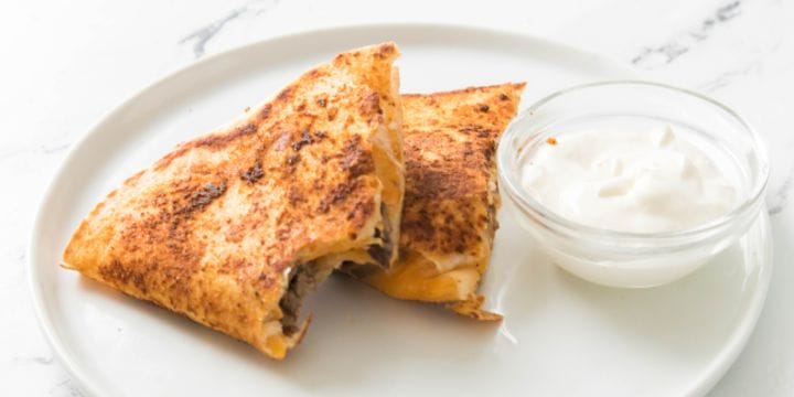 steak quesadillas on a plate with one bite out