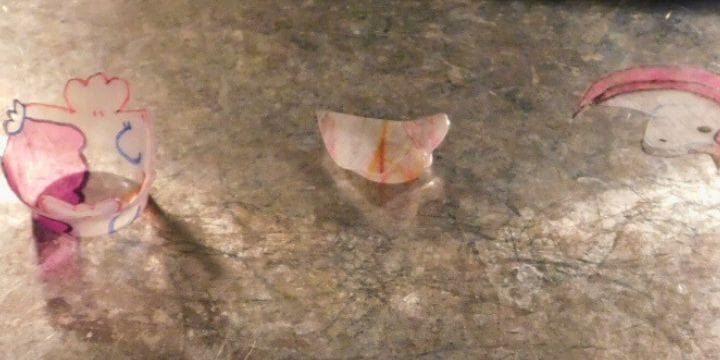 shrinky dinks shrinking on a pan in the oven