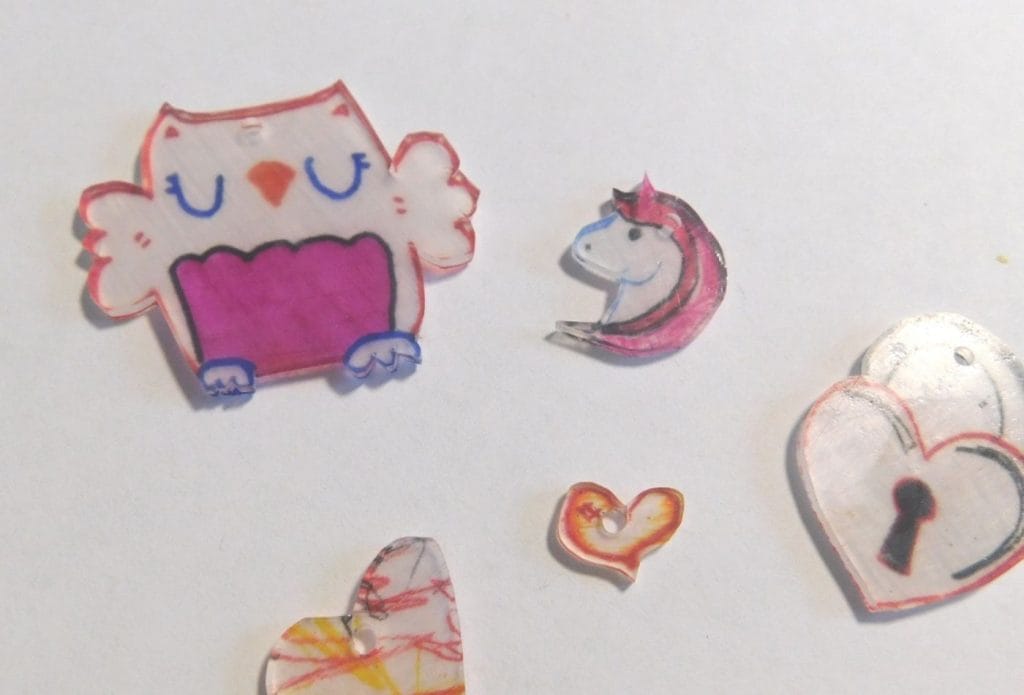 plastic shrinky dinks in valentine colors on a board