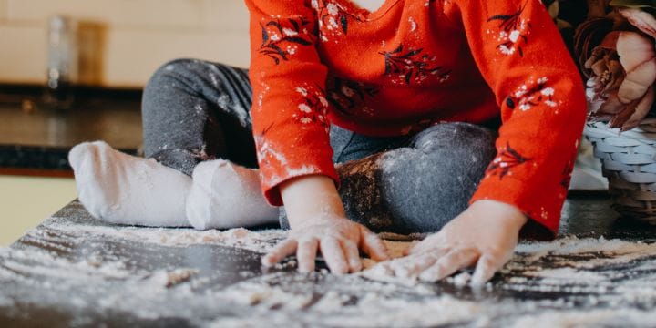a toddler feeling flower on a rug