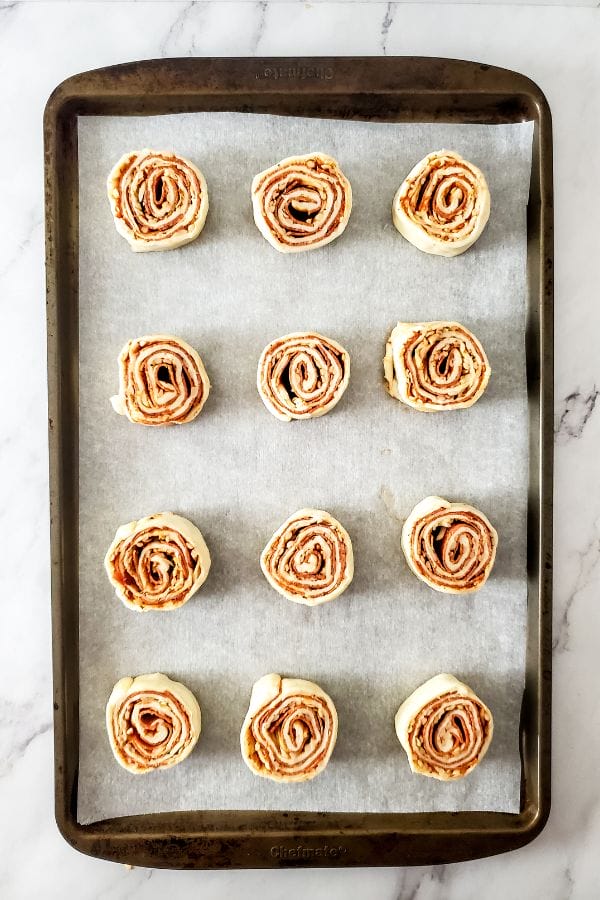 pizza rolls on a sheet tray ready to bake