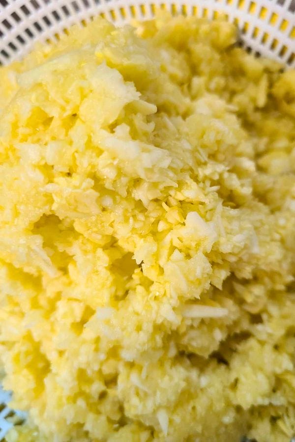 riced yellow squash draining in a bowl