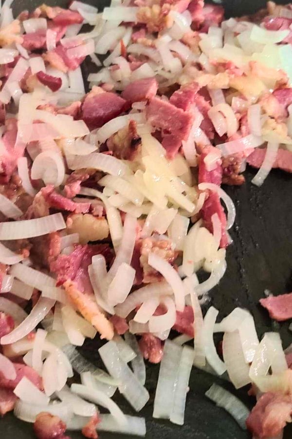 onions and bacon cooking in a pan