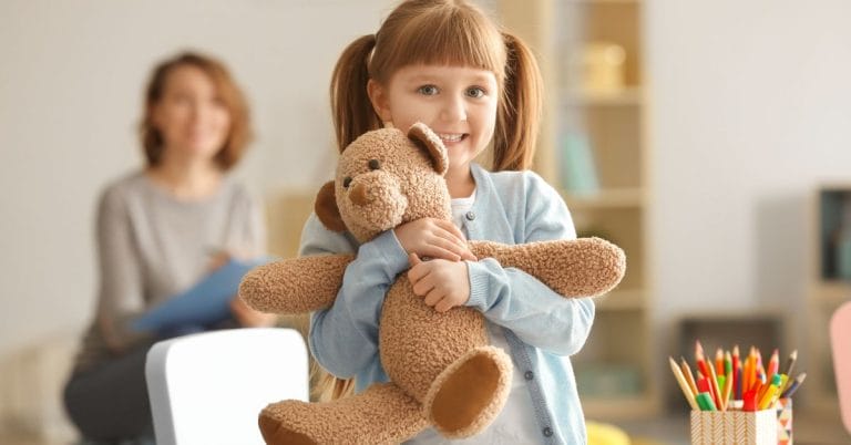 a child holding her teddy bear
